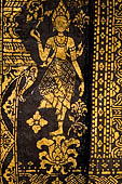 Wat Xieng Thong temple in Luang Prabang, Laos. Detail of the  intricate gold stencilling on black lacquer that decorate the walls of the sim. 